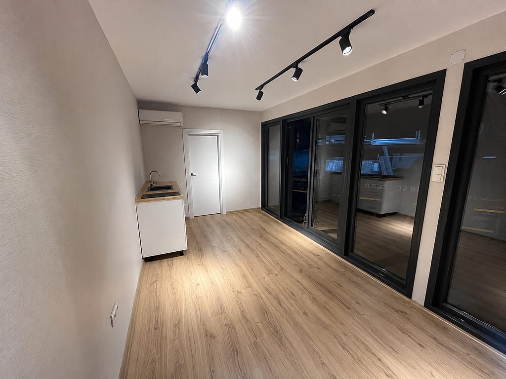 Wohncontainer Modell PRESTIA 300 × 700 cm – Innenansicht mit Küche und Verglasung